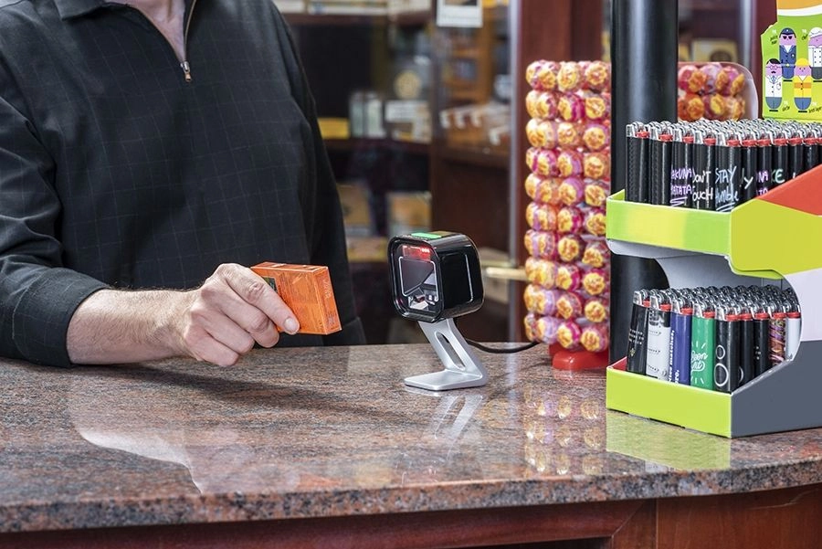 Datalogic Magellan 1500i black USB presentation scanner reading a 1D/2D barcode at a retail checkout counter
