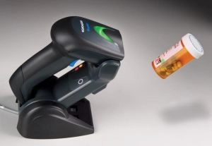 Refurbished Datalogic Gryphon GM4400 wireless 1D/2D barcode scanner on USB dock scanning a medicine bottle for POS and warehouse use